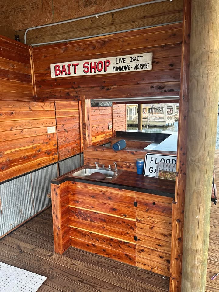 Custom bait shop with live bait sign, crafted from Eastern Red Cedar, featuring a sink and storage, set in a lakeside dock environment.