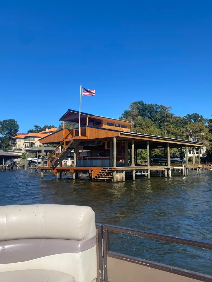 Custom boat dock in Shreveport, Louisiana, featuring Eastern Red Cedar construction, Tongue & Groove panels, and a scenic lakeshore setting with an American flag.