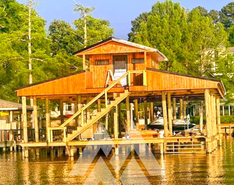 Lakeside boathouse featuring Eastern Red Cedar siding and trim, elevated on pilings with a covered boat slip, showcasing the durability and natural beauty of cedar lumber from Mountain Milling Co.