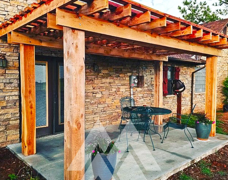 Custom cedar pergola built from Eastern Red Cedar posts and beams, creating a rustic outdoor patio space with natural wood durability and charm, crafted from Mountain Milling Co. cedar lumber