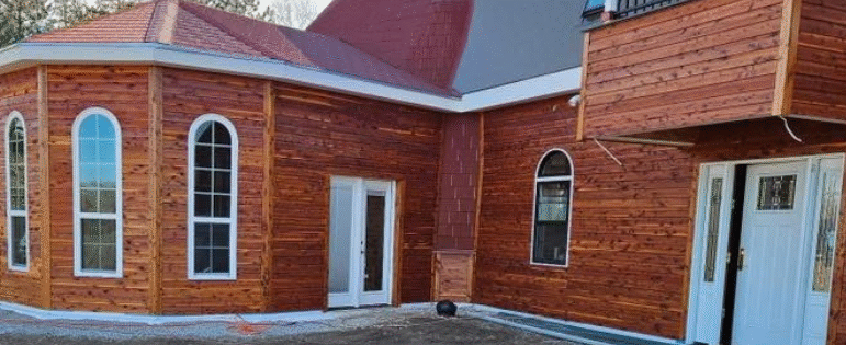 Geometric dome-style home in Hutchinson, Kansas finished with Mountain Milling Co. Eastern Red Cedar Dutch Lap siding, showcasing the warm natural wood tones that enhance the modern architectural design