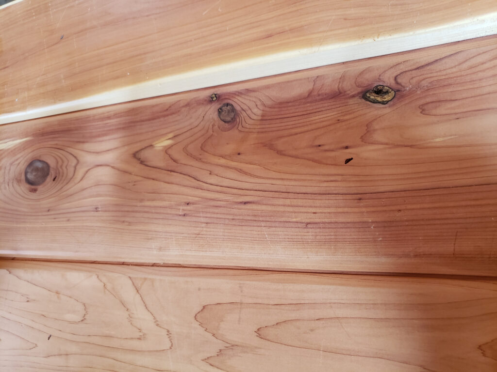 Tongue-and-groove aromatic cedar planks showcasing interlocking edges, highlighting natural wood grain and knots, ideal for closet liners and moisture control.