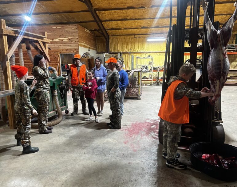 The McKee family processing a deer at the sawmill after a successful hunt